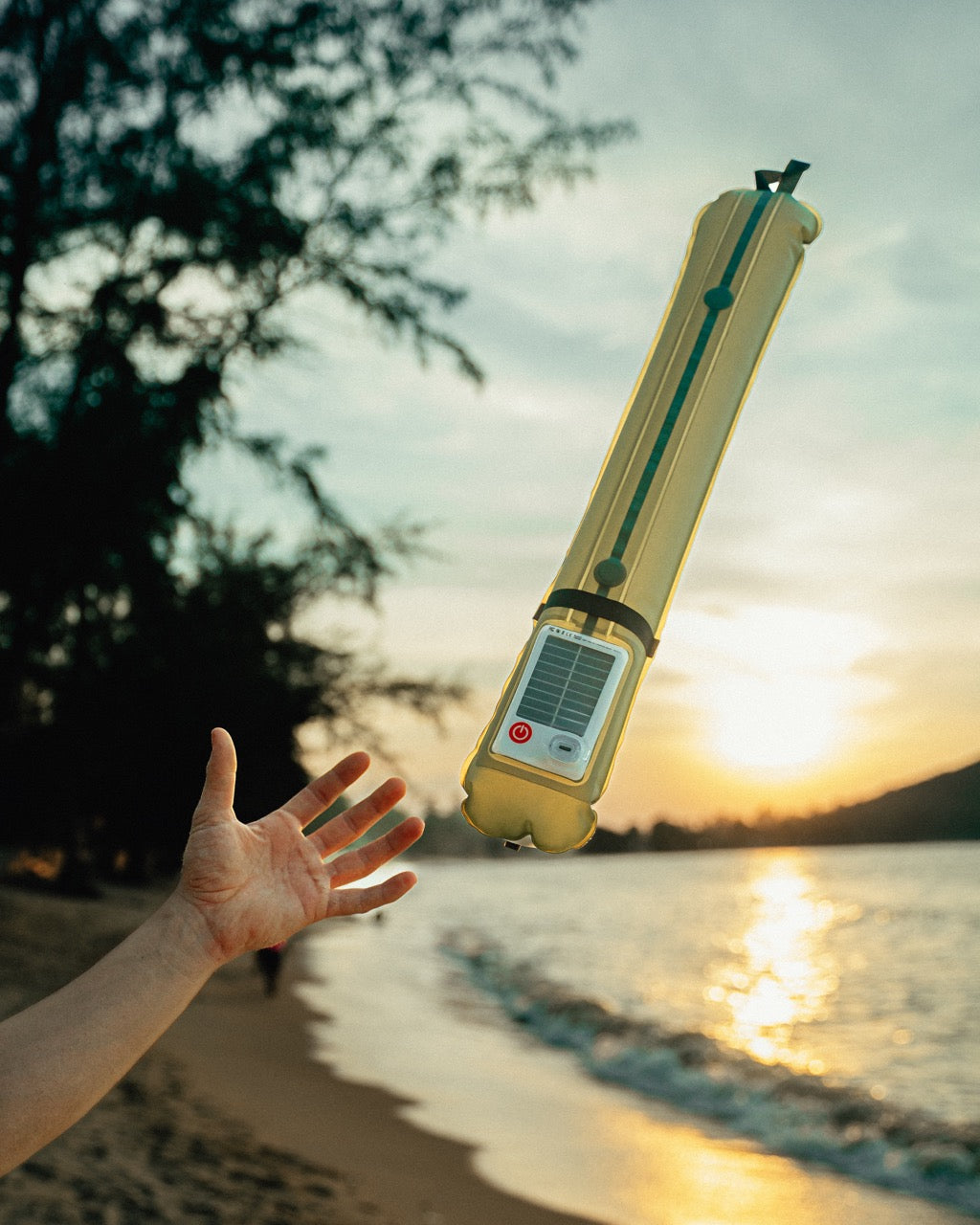 Glowmad portable light on a beach at sunset showing solar charging. 